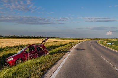 red car in ditch next to road | worst American highways