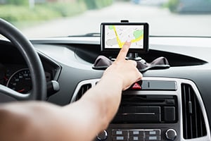 Close-up Of Female's Hand Programming a Navigation System While Driving
