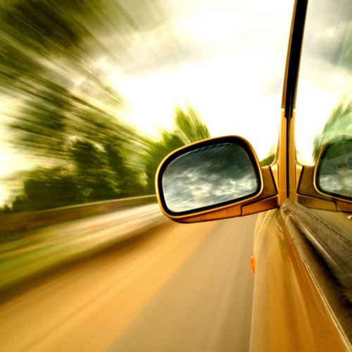 driver side view mirror of speeding car | the dangers of speeding