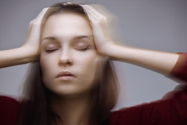 young woman holding her head experiencing Dizziness after a Car Accident