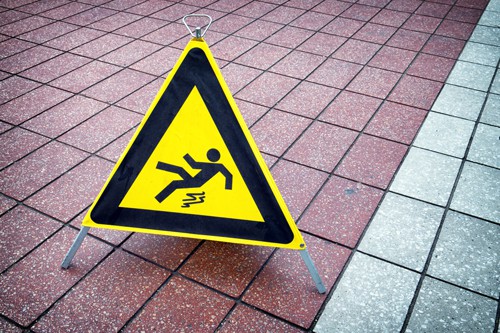 caution wet floor sign on tile floor | How to File a Slip and Fall Claim