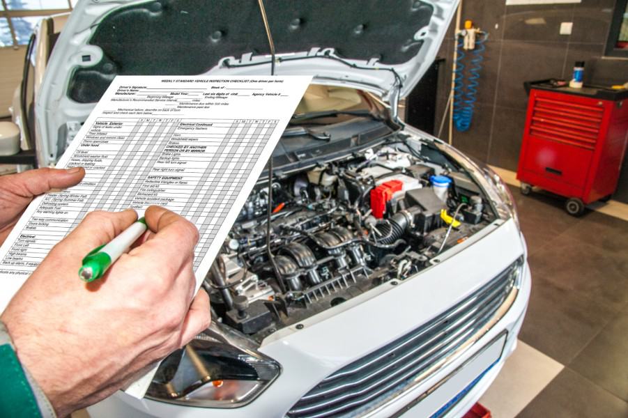 person checking a car engine | car maintenance