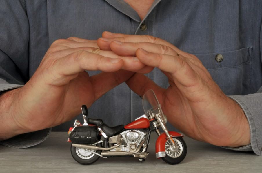 man covering a miniature bike with his hands | Cost to Insure a Motorcycle in Colorado