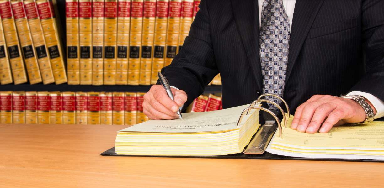 lawyer writing on a book | Broomfield pedestrian accident attorneys