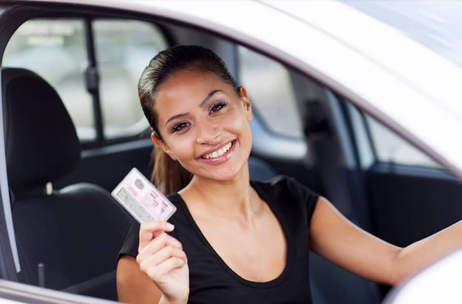 woman smiling while holder her driver license | safest cities in colorado